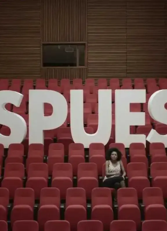 Mujer sentada frente a letras gigantes que forman la palabra RESPUESTA Mujer sentada frente a letras gigantes que forman la palabra RESPUESTA