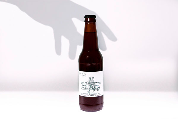 fotografia de botella de cerveza jack The Ripper sobre fondo blanco y sombra de una mano en la pared, cerveza artesanal, cerveza artesanal colombia