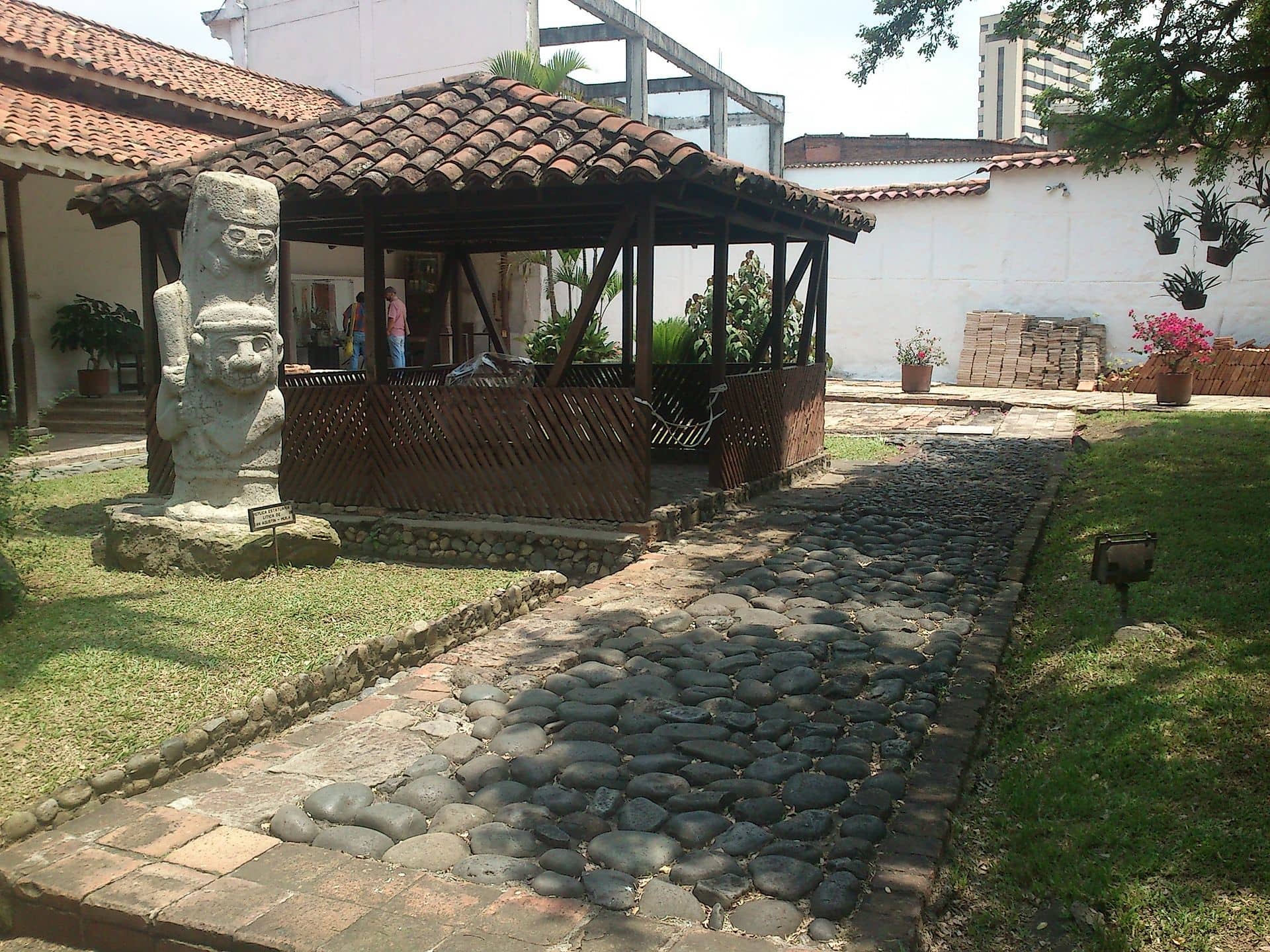 La Merced Museum courtyard. A San Agustín monolith stands next to a kiosk.