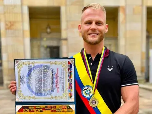 Dominic Wolf recibiendo la cinta presidencial Honor de la Excelencia y la Cruz de la Solidaridad Social 2022.