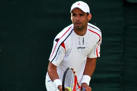 Alejandro Falla en cancha de tenis concentrado antes de un saque