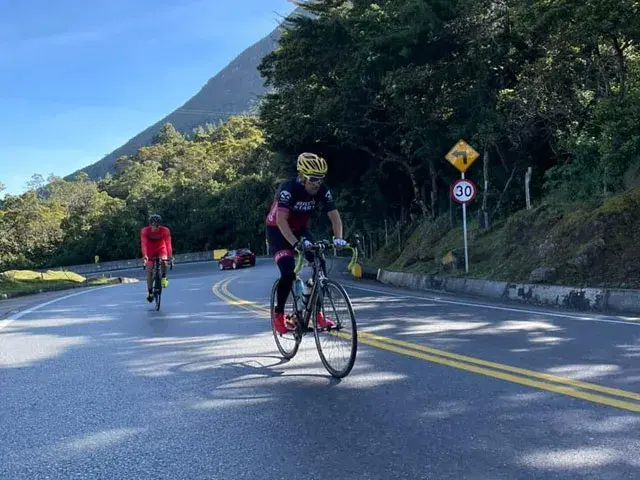 Dos ciclistas subiendo una carretera de montaña en Colombia.