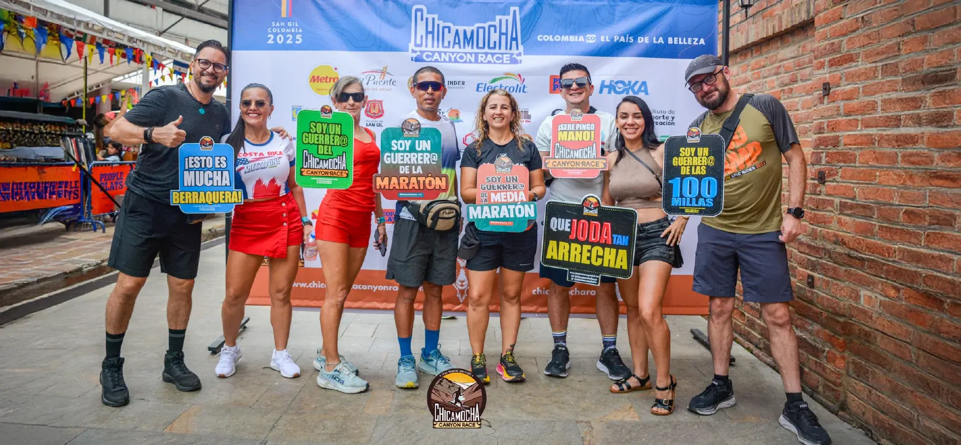 Group of people posing with colorful signs at the Chicamocha Canyon Race 2025 in San Gil, Colombia