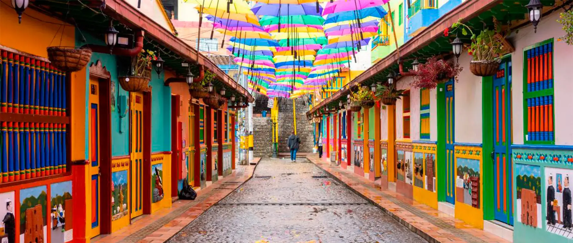 Calle de los Paraguas in Guatapé, with colorful umbrellas hanging over a cobblestone street