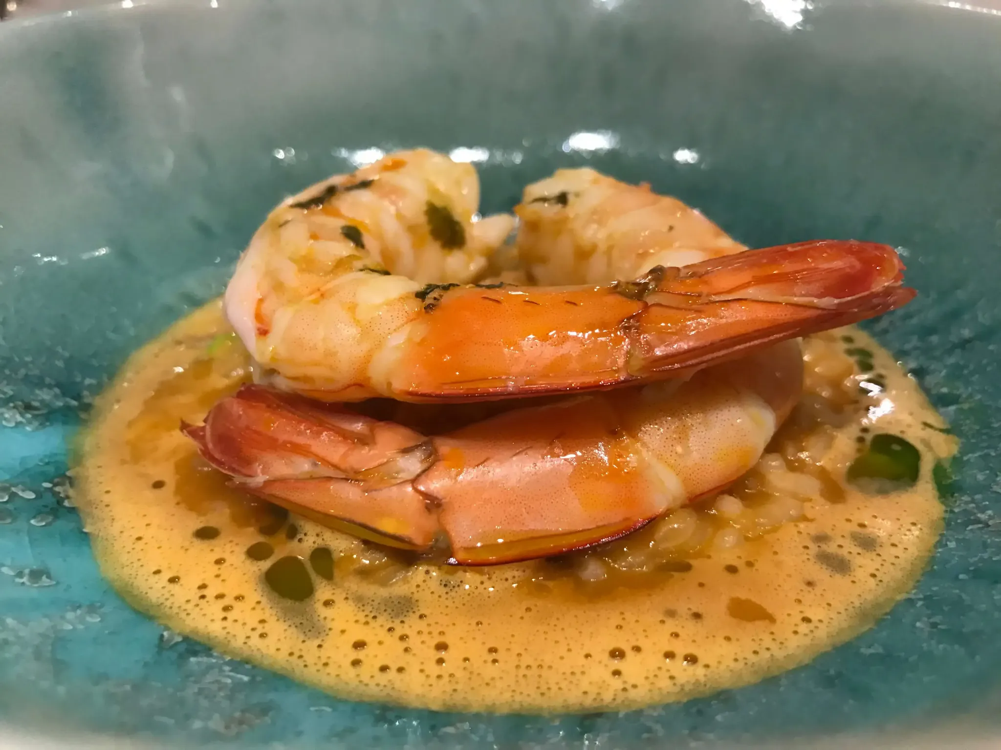 Plato de camarones en salsa servido en un plato azul