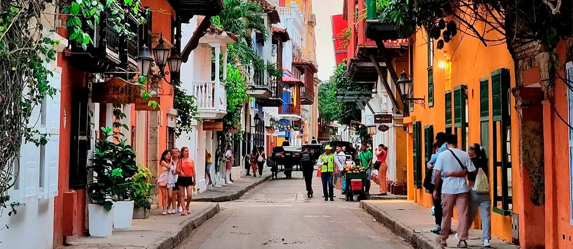 Carrera 4 in Cartagena de Indias, amidst colonial balconies with the Santa Catalina de Alejandría Cathedral in the background