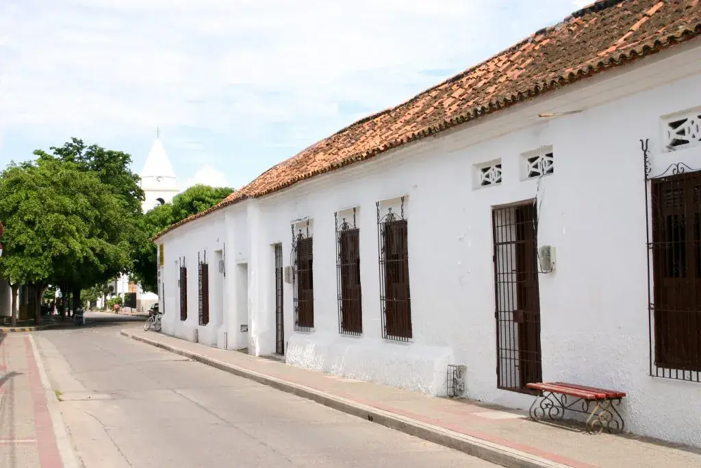 Calle tranquila con casas blancas y techo de tejas rojas en Mompox, Colombia.