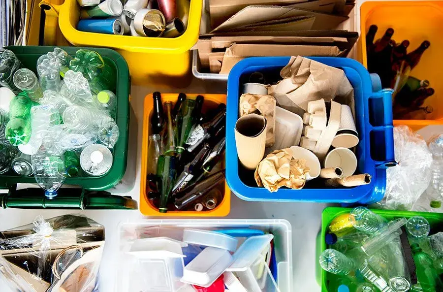 Contenedores de reciclaje llenos de diferentes materiales.