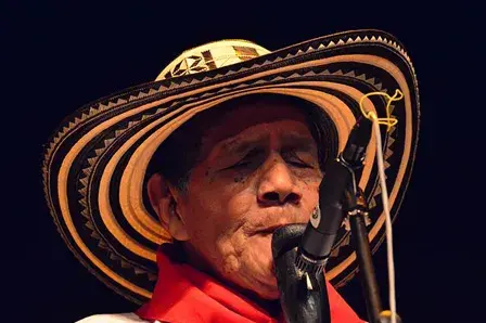 Piper playing the gaita with a sombrero vueltiao.