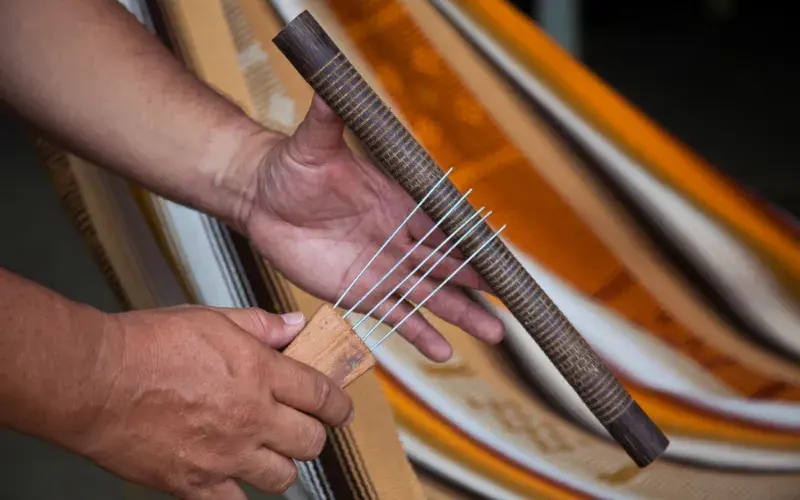 Hands playing a Colombian guacharaca.