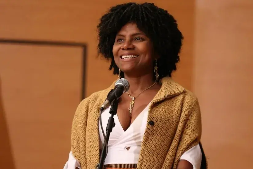 Mabel Gisela Torres sonríe mientras canta en un micrófono.