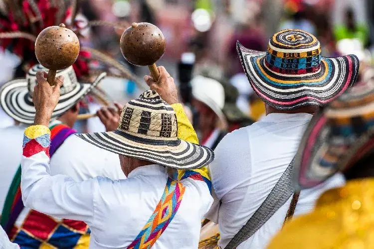Hombres con sombreros vueltiaos tocando maracas durante una presentación de cumbia colombiana.