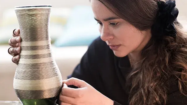 Woman inspecting a ceramic craft.