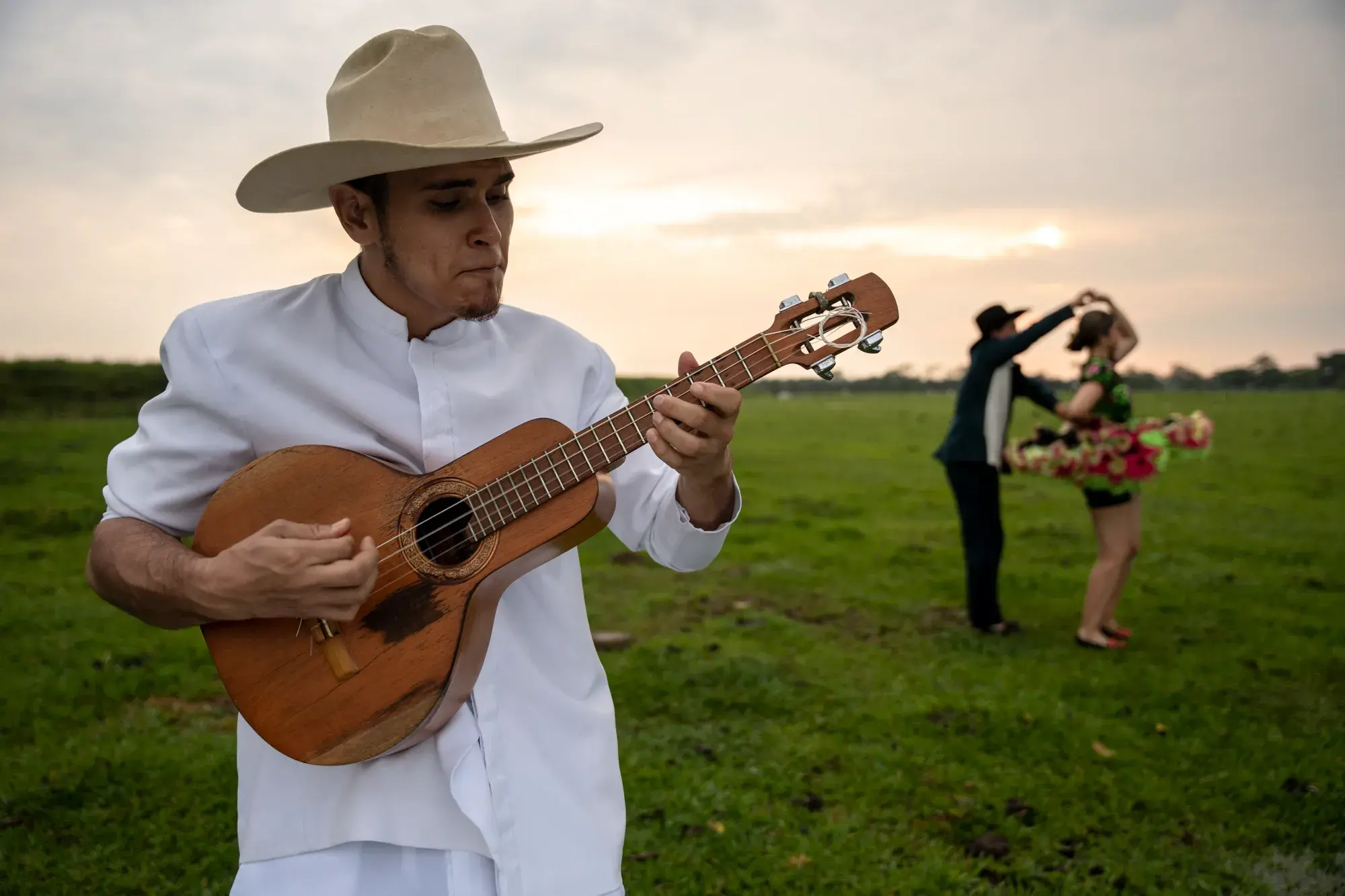 Músico tocando bandola en los Llanos Orientales con pareja bailando.