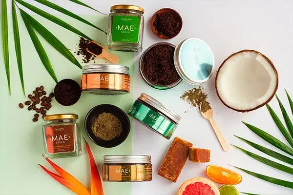Productos de belleza Mae con coco, café y frutas tropicales.