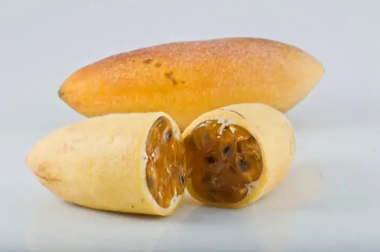 Whole yellow curubas and one cut in half showing the pulp.