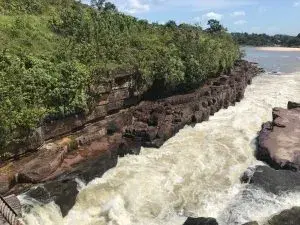 Río rápido entre rocas y vegetación exuberante.