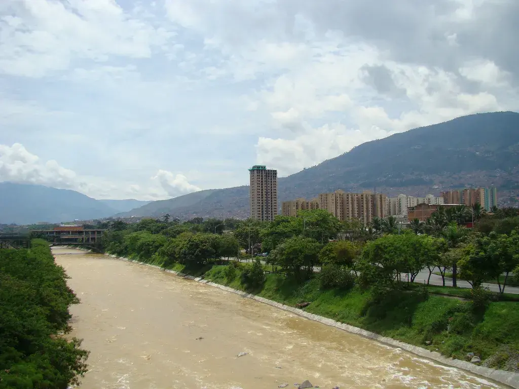 Río Medellín con edificios y montañas al fondo