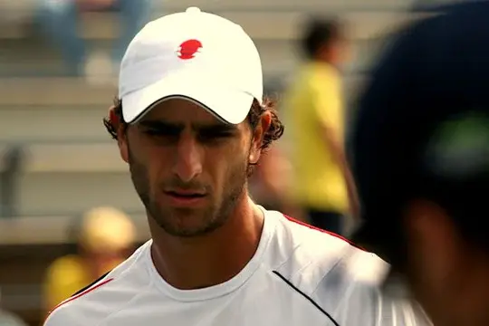 Robert Farah durante un torneo profesional de tenis con gorra blanca