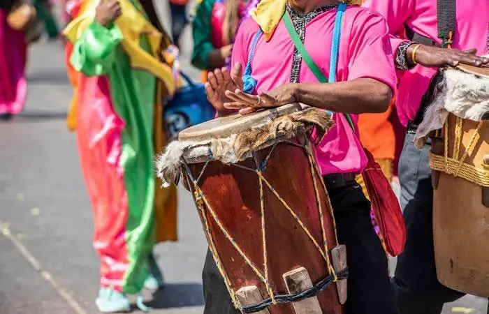 Musicians playing drums in a colorful parade.