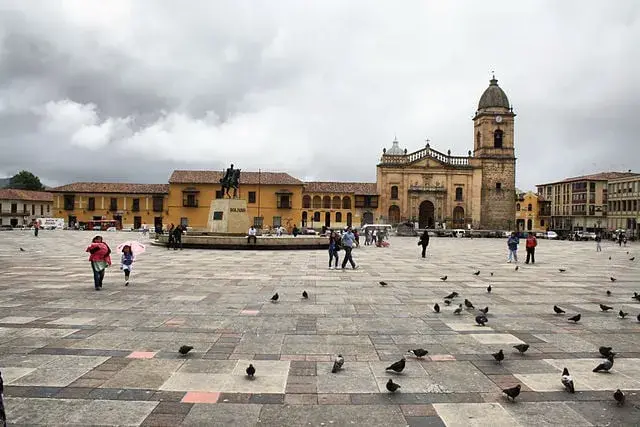 Colombia cold zone, square with monument, birds and people. In the back the Cathedral, tunja, plaza de Bolivar