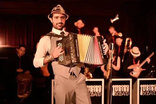Gregorio Uribe tocando acordeón en el escenario