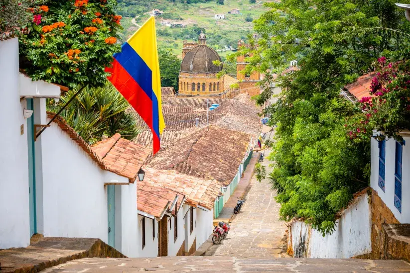 Vista de calle empedrada en Barichara con bandera colombiana. ¡Es un pueblo muy bonito!