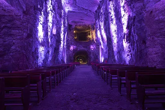 Interior de la Catedral de Sal iluminada con luces moradas.