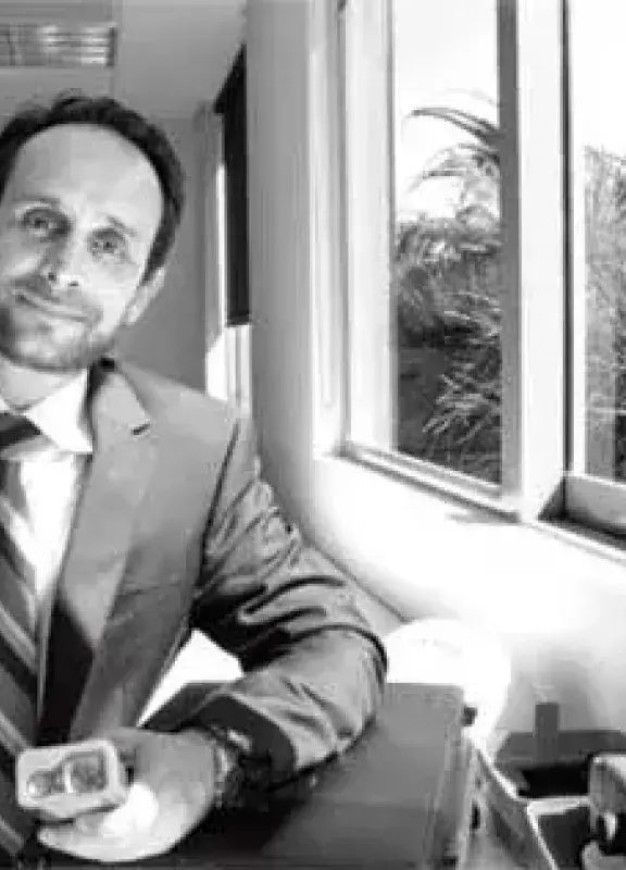 Man in a suit next to a window in an office Man in a suit next to a window in an office