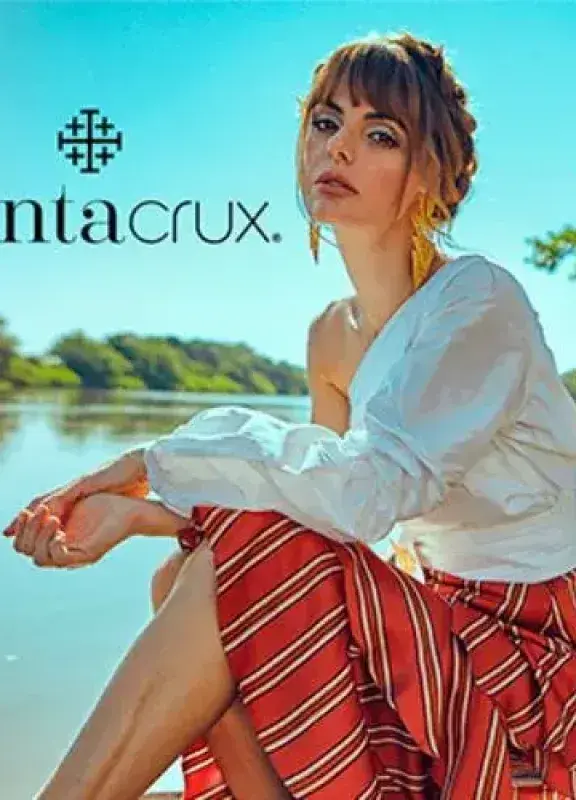 Woman in white blouse and striped skirt posing in boat on river with Santa Cruz logo Woman in white blouse and striped skirt posing in boat on river with Santa Cruz logo