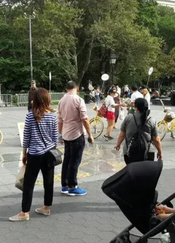 Personas en plaza interactuando con bicicletas amarillas de Colombia en paz Personas en plaza interactuando con bicicletas amarillas de Colombia en paz