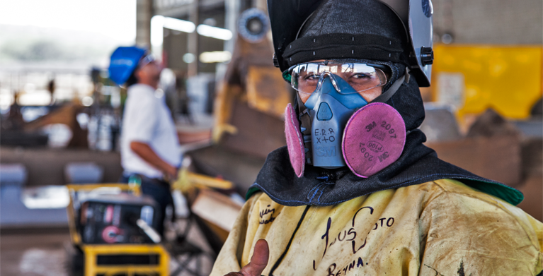 fotografía de una persona en una construcción con un tapabocas grande viendo frente a la camara, Mineria en Colombia, exportaciones, productos mineros