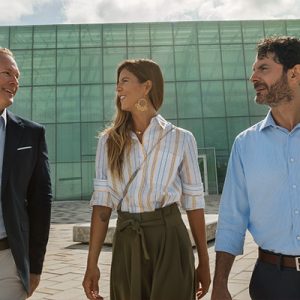 Tres personas caminando y sonriendo con fondo de edificio atras, oportunidades de negocio en Colombia, estudio de oxford