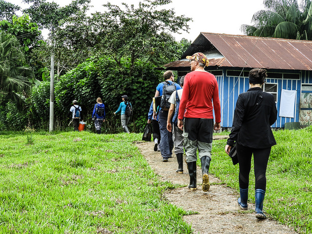  personas caminando por sendero ecológico con casa azul de fondo,Reserva Natural Cañón del Río Claro, biodiversidad colombiana