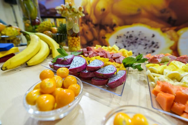 Mesa llena de frutas típicas colombianas como uchuvas, banano, pitaya, frutas colombianas, recetas de jugos naturales
