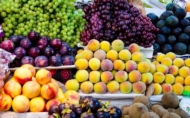 plaza de mercado con Frutas y verduras colombianas, melón, durazno, uvas, recetas de jugos naturales
