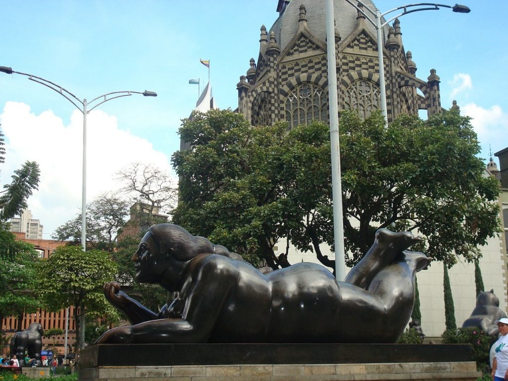 Imágen de escultura de Fenando Botero en Medellin con catedral de fondo, esculturas de botero, la ciudad de la eterna primavera, Medellin Colombia, turismo Colombia