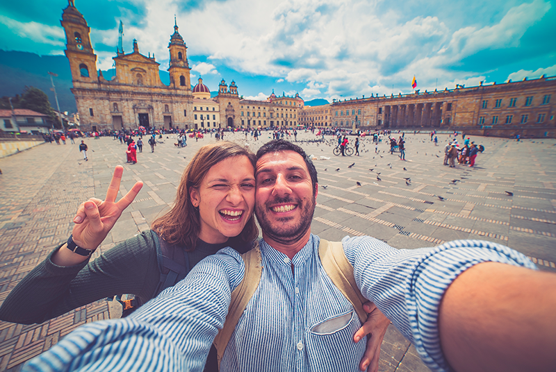 Turistas que recorren Colombia, el país más acogedor del mundo se sienten felices - Dos turistas tomándose una selfie en el centro de Bogotá, Colombia | Marca País Colombia