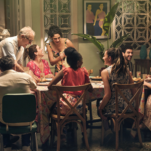Fotografía de familia reunida en la mesa riendo y compartiendo juntos, familias colombianas