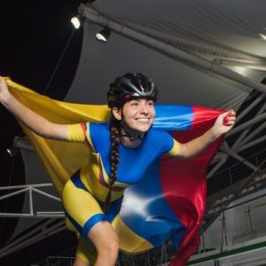 Deportistas colombianos llevando con orgullo la bandera de Colombia en un estadio