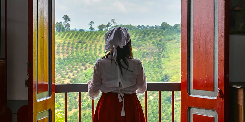 Mujer campesina contempla el paisaje cultural cafetero en Colombia.