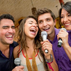 La amistad de colombianos divirtiéndose mientras cantan karaoke juntos