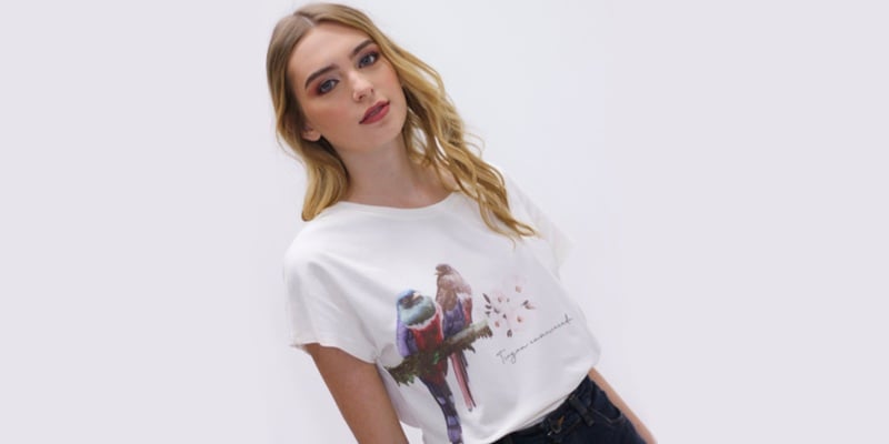 Modelo exhibiendo camiseta con diseño de aves colombianas